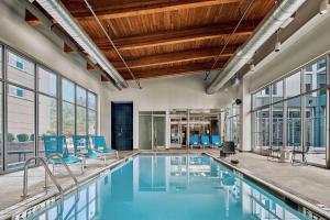 汉诺瓦BWI机场阿伦德尔米尔斯雅乐轩酒店的一个带蓝色椅子和窗户的室内游泳池