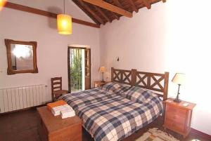 贝瑙汉Molino del Caracol的一间卧室配有一张带 ⁇ 子毯子的床