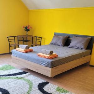蒂拉斯波尔Like Home Hostel的一间卧室设有一张黄色墙壁的大床