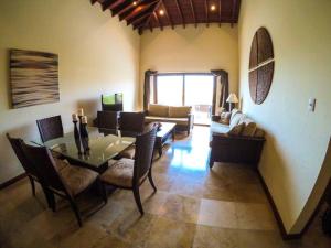 罗阿坦Relax Enjoy Upscale Villa Pristine Bay的客厅配有餐桌和沙发