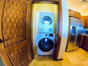 罗阿坦Relax Enjoy Upscale Villa Pristine Bay的门旁厨房里的洗衣机和烘干机