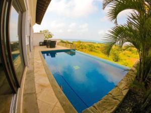罗阿坦Relax Enjoy Upscale Villa Pristine Bay的房屋前的游泳池