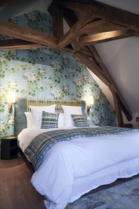 阿朗松Les Deux Marguerite的卧室配有白色床和花卉壁纸
