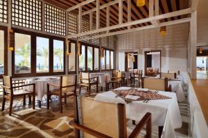 达哈布Retac Qunay Dahab Resort & SPA的餐厅设有白色的桌椅和窗户。
