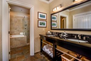 林奇堡Craddock Terry Hotel, Lynchburg, a Tribute Portfolio Hotel的浴室设有2个盥洗盆、淋浴和镜子。