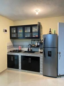 圣多明各Tiny Apartment By Merengue House的厨房配有不锈钢冰箱和黑色橱柜