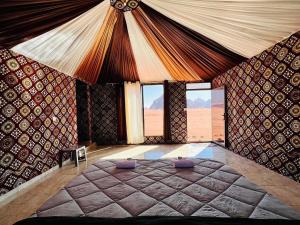 瓦迪拉姆Salameh's Bedouin Camp的一间带一张大床的卧室,位于带窗户的房间内