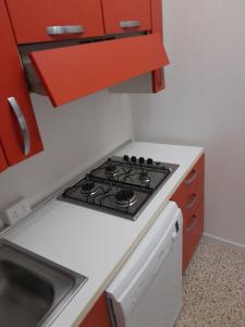奥里斯塔诺Da Julia的厨房配有炉灶和红色橱柜。