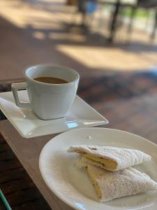 阿奎拉兹Pousada Brisa do Mar的一杯咖啡和一块夹三明治的盘子