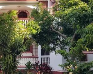 海地角La Difference Guest House的一座树木繁茂的房子的白色前门