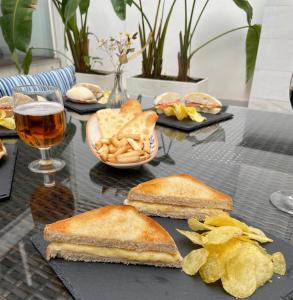 科尔多瓦奥萨里奥之门精品酒店的一张桌子,上面放着三明治和薯条,还有一杯啤酒