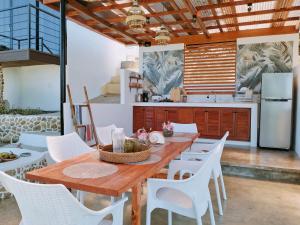 BariliLas Terrazas de Barili的厨房配有木桌和白色椅子
