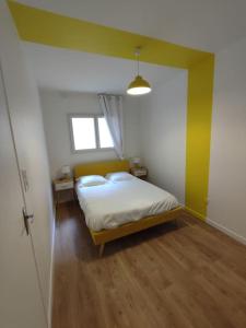 卢尔德Appartement Le Secret, Proche Sanctuaires的一间卧室设有一张床和黄色的墙壁