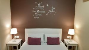 巴塞罗那佩蒂特普里塞普旅馆的一间卧室配有一张带两张桌子和两盏灯的床。