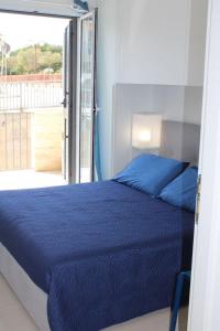 拉古萨码头Sikelia的一间卧室设有蓝色的床和一个阳台