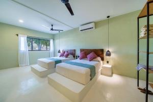 圣克鲁斯华特库Hotel Bindani’的绿墙客房内的两张床