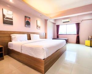 南邦AIRBEST Gemtree Lampang Hotel的一间卧室,卧室内配有一张大床