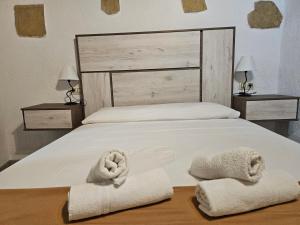 卡索拉La Cueva de Juan Pedro的一间卧室配有一张床,上面有两条毛巾