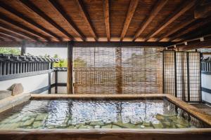 伊东伊豆Cocoグランピングリゾート的后院的水池,带有木制天花板