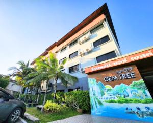 南邦AIRBEST Gemtree Lampang Hotel的前面有标志的建筑