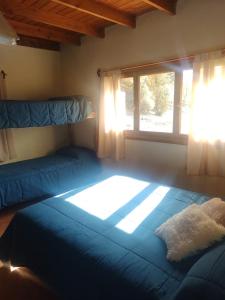 圣卡洛斯-德巴里洛切Posada del Ñireco的一间卧室设有两张床和窗户。