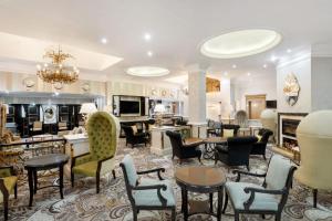 约翰内斯堡约翰内斯堡桑顿三角琴万豪Protea酒店的大型客厅配有桌椅
