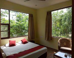 Uttar SimlabariNalgarh Retreat - JUNGLE RESORT by StayApart的一间卧室设有一张床和两个大窗户