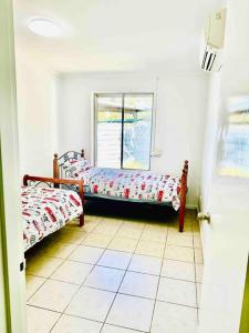 艾利斯斯普林斯Grabber- Three bedroom charm in Alice Springs的客房设有两张床和窗户。