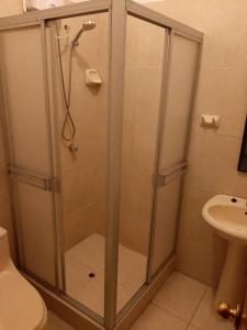 伊基托斯203 RV Apartments Iquitos-Apartamento con dos habitaciones的浴室里设有玻璃门淋浴