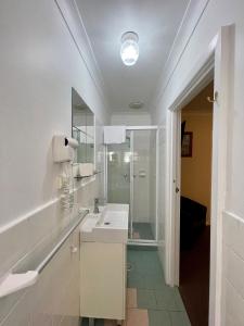 悉尼北岸酒店的白色的浴室设有水槽和淋浴。