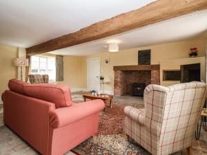 萨克斯曼德姆South Grange Cottage的客厅配有两把椅子和壁炉