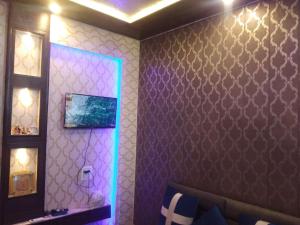 贾姆穆ASHIANA HOME STAY的一间设有一面紫色墙壁和镜子的客房