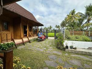 特特巴图Mysha Guest House-Lombok的坐在房子旁的院子中的轮椅的人