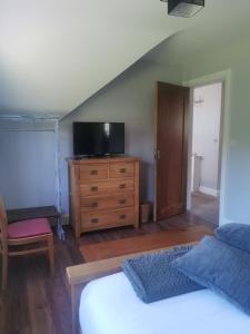 Canaima House的一间卧室配有一张床和一个带电视的梳妆台。