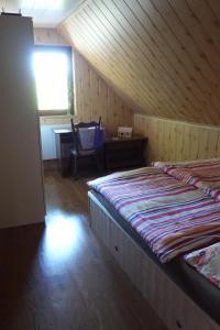 Dolní BrusnicePod Lípou的一间卧室设有两张床、一张桌子和一个窗口。