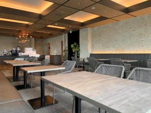 仓敷Royal Park Hotel Kurashiki的一间在房间内配有桌椅的餐厅