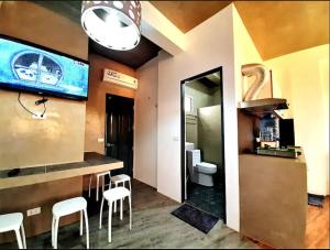波尔多·格尼拉Ship MARIA Hotel的客房设有带白色凳子的酒吧和浴室