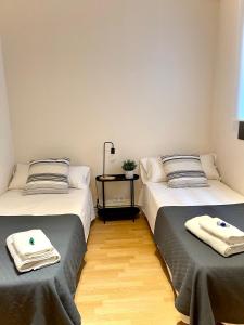 埃普拉特约布里加Barcelona PR Guesthouse的两张睡床彼此相邻,位于一个房间里