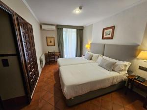努瓦洛斯石头修道院酒店的酒店客房配有一张床铺和一张桌子。