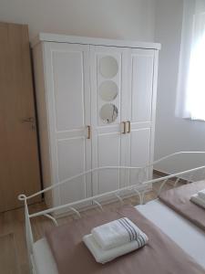 斯塔利格拉德-帕克利尼卡Apartmani Tin的卧室配有白色橱柜和1张床