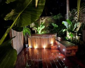 拜伦湾Beach Jungle - Hot Tub, Firepit & Pool in Beachside Oasis的木地板,配有种植了植物的大型木制浴缸
