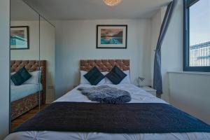利物浦Bright & Comfortable 2-Bedroom Central Flat with Parking的一间卧室设有一张大床和两个窗户。