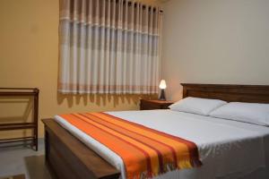 PeliyagodaParamount Residence - 7的一间卧室配有一张带橙色毯子的床
