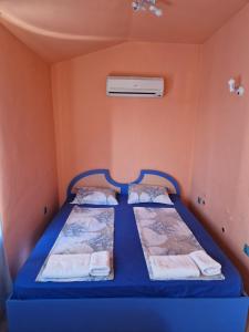 普里莫尔斯科达拉酒店的配有橙色墙壁的小客房内的两张床