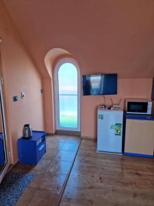 普里莫尔斯科达拉酒店的厨房设有拱形窗户和冰箱