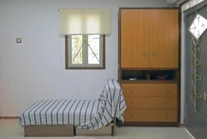 卡拉马塔VENI Olive House的一间卧室配有一张床、一个梳妆台和一扇窗户。