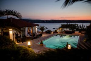 苏佩塔斯卡德拉加Miral Apartments的黄昏时可欣赏到海景的游泳池