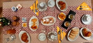 圣安蒂奥科B&B La Jacaranda affittacamere的一张桌子,上面放着糕点盘和餐具