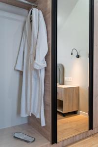奇姆肯特BnB Hotel Shymkent的浴室里挂着白色长袍的镜子