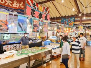 鸟取市Whole house rental 一棟貸切宿 "Your Home Tottori" 市内中心地近くの素敵な一軒家的一群站在海鲜市场的人